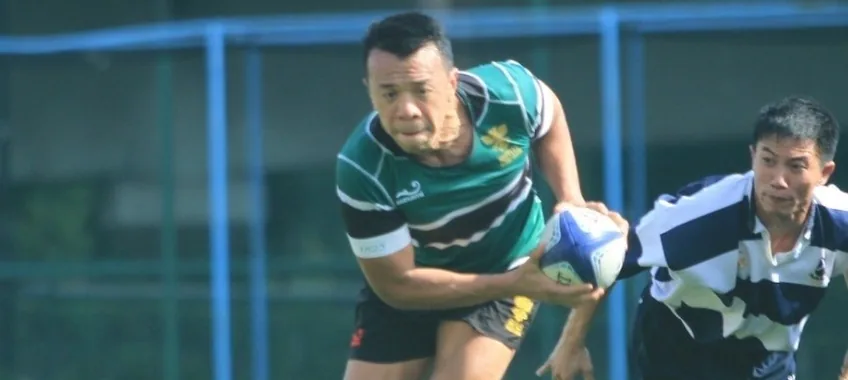 Dr Lai membawa bola dalam pertandingan rugbi tahun 2019